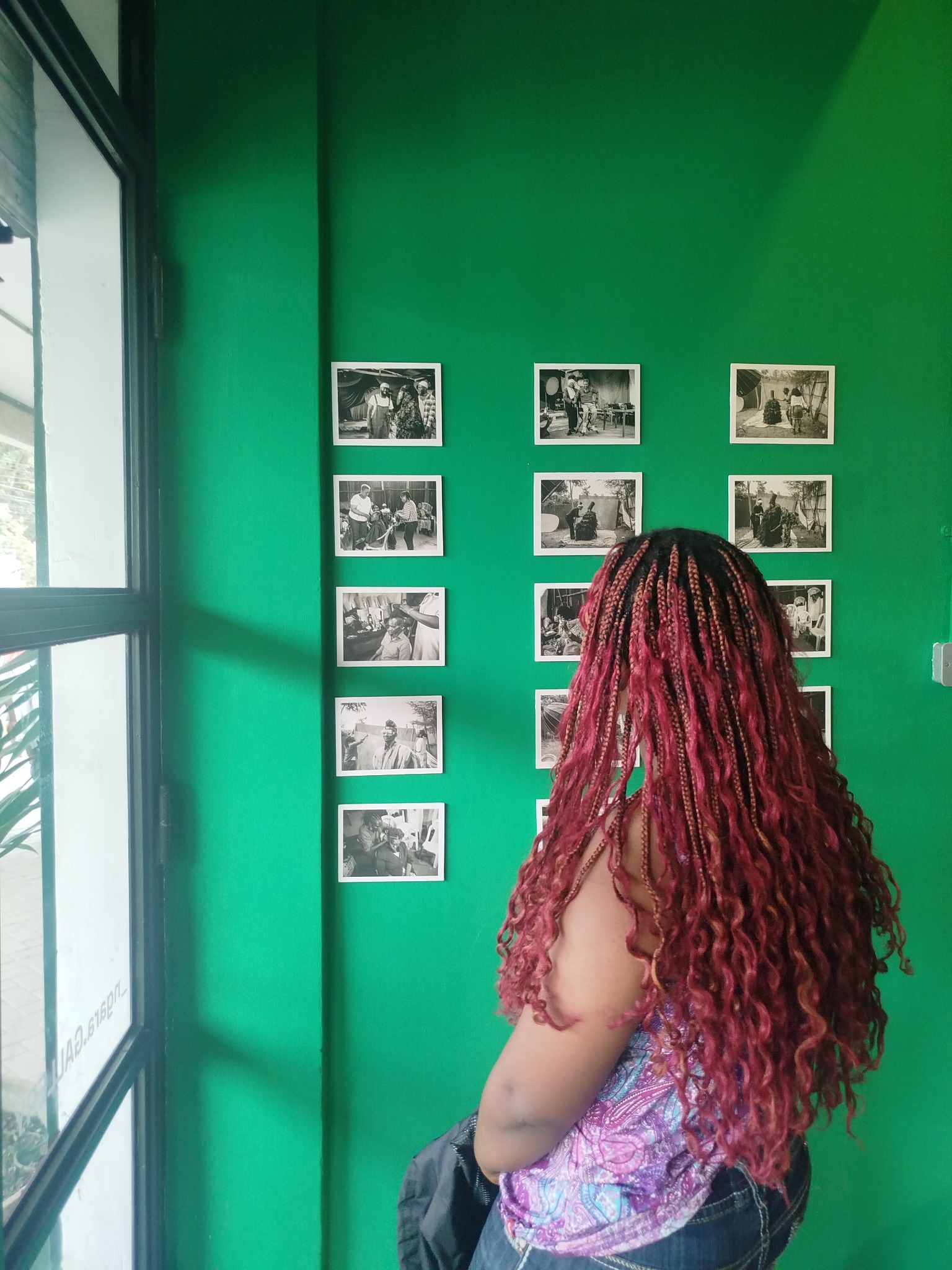 Juanita exploring a green-walled photography gallery